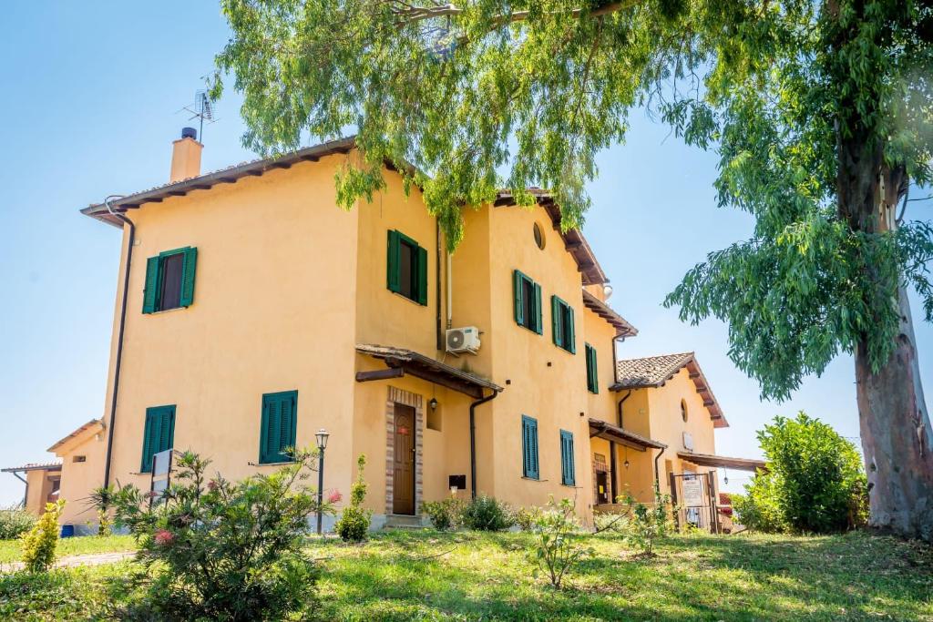 an italian villa with a tree in the foreground at Il Casale Di Roma in Prima Porta