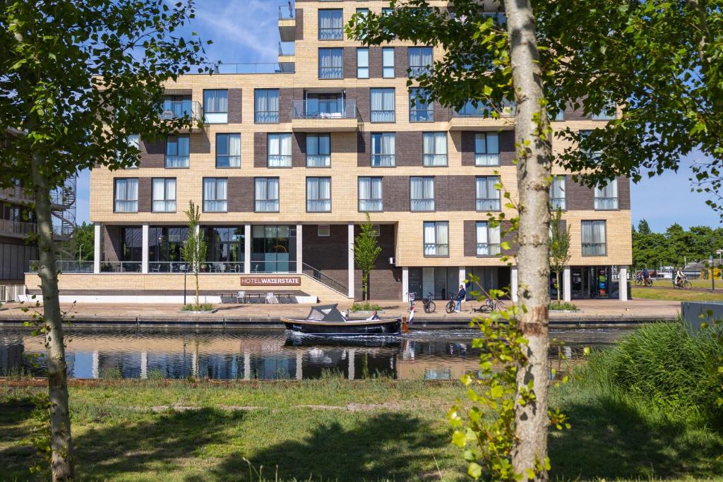 ein Gebäude mit einem Boot davor in der Unterkunft Waterstate Wellness hotel Goes in Goes