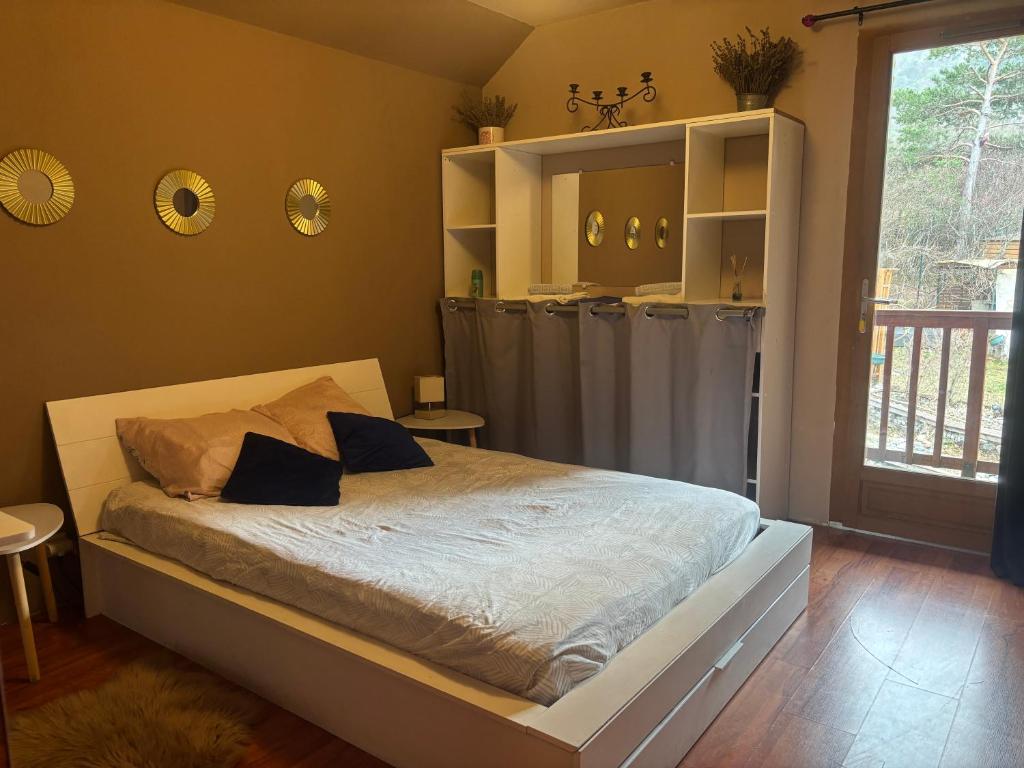 a bedroom with a large bed with gray curtains at Chambre Morgon in Savines