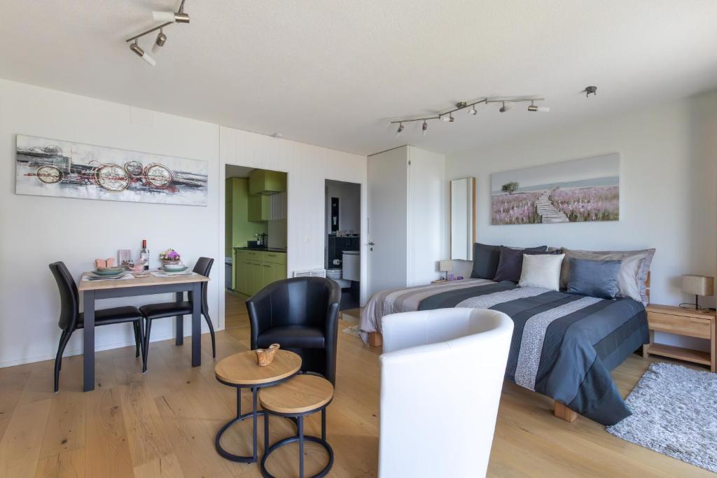 a bedroom with a bed and a dining room at Ferienwohnung Schwyz in Schwyz