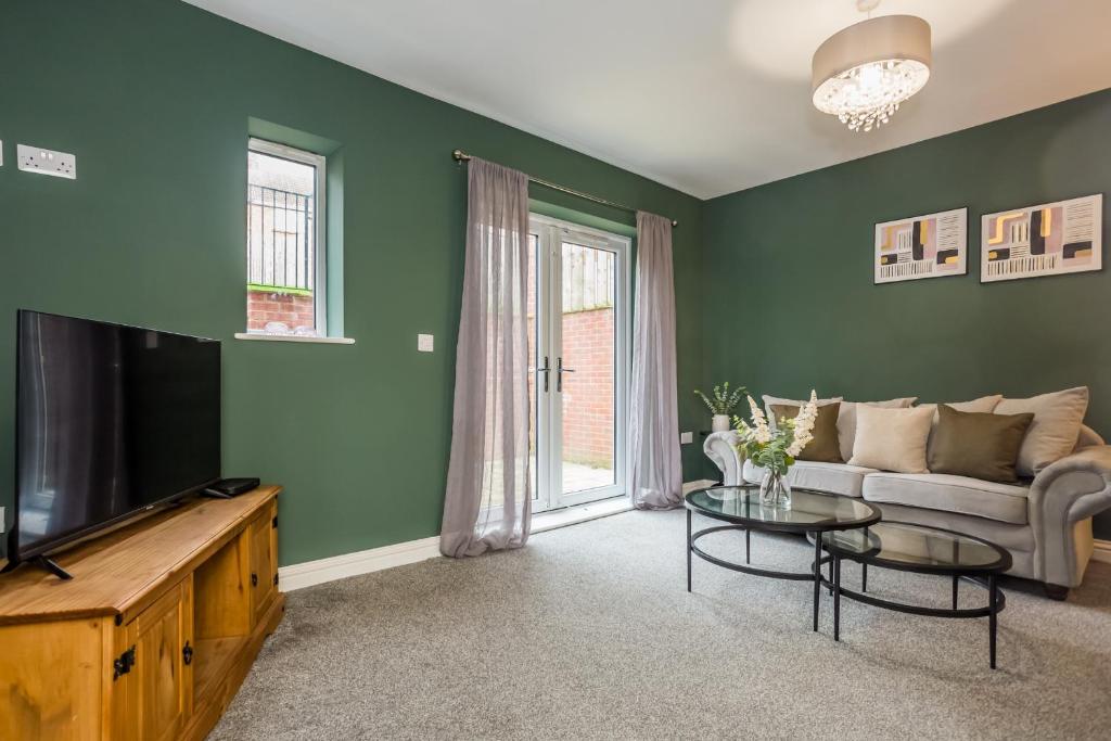 a living room with a couch and a tv at 61 Deneside in Lanchester