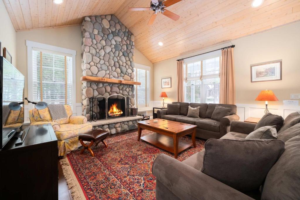 a living room with a couch and a fireplace at Pine Trace Escape in Glen Arbor in Glen Arbor