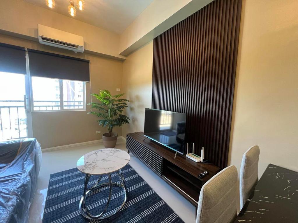 a living room with a television and a table and chairs at KEY REALTY SERVICES Ph in Pajak