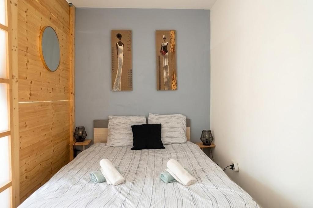 a bedroom with a bed with two pillows on it at Doux Pavillon - Le Patio in Nice