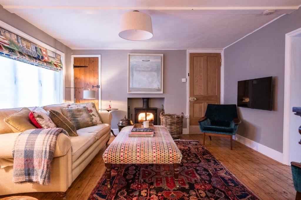 a living room with a couch and a fireplace at Hollyhocks, Tunstall in Tunstall