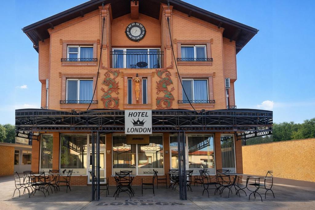 a building with tables and chairs in front of it at Хотел ЛОНДОН in Svilengrad