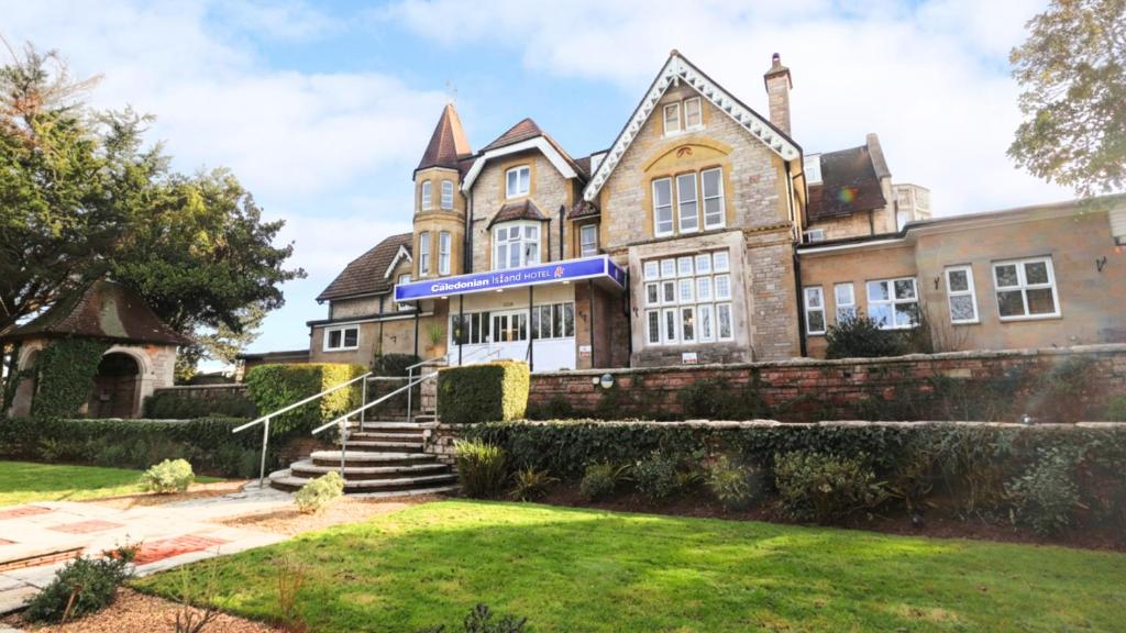 an old house with a lawn in front of it at The Caledonian Island Hotel in Sandown