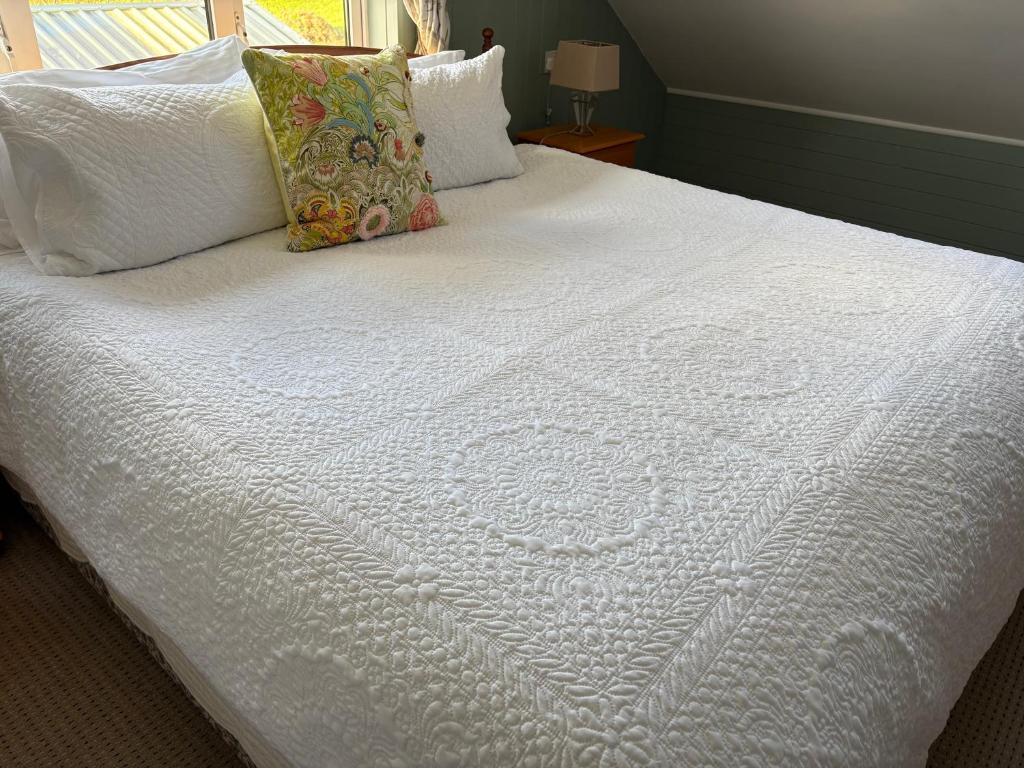 a bed with white sheets and pillows on it at Cliff View Lodge Apartment in Liscannor