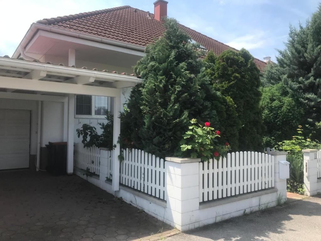 a white fence in front of a house with a christmas tree at Ferienhaus Marhardt in Oslip