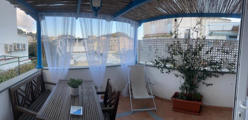 a balcony with a table and chairs and a window at Piazzetta Sweet Home in Capri