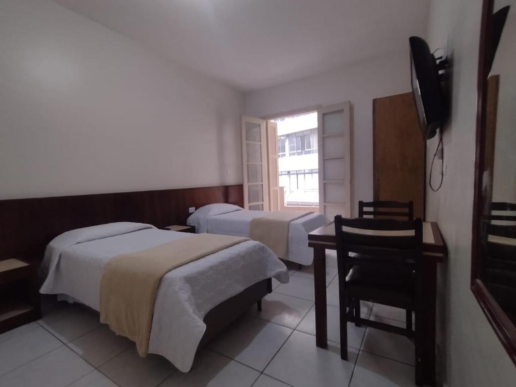 a hotel room with two beds and a television at Hotel Plaza Olido in São Paulo