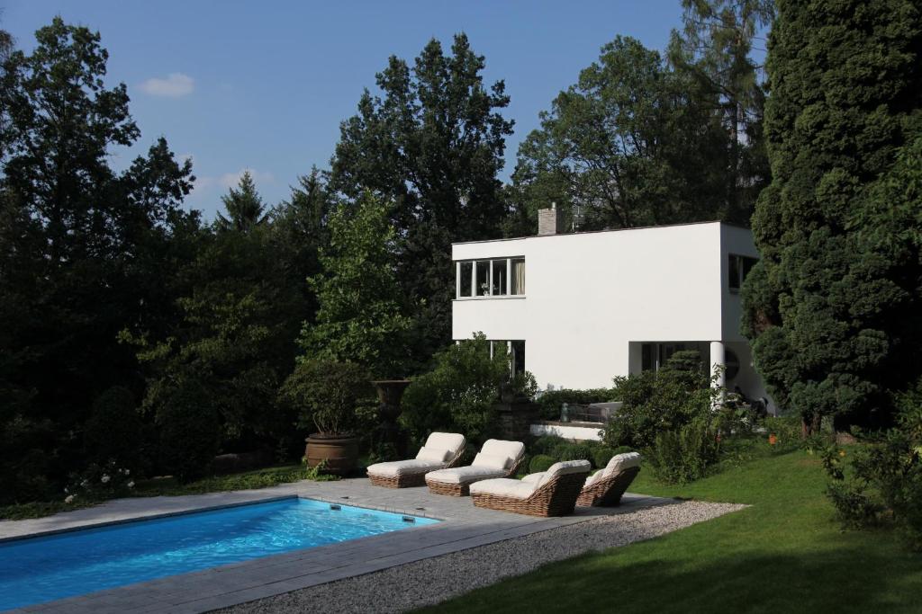 a house with a swimming pool in front of a house at Villa Čisovice - Functionalist Retreat near Prague in Čisovice