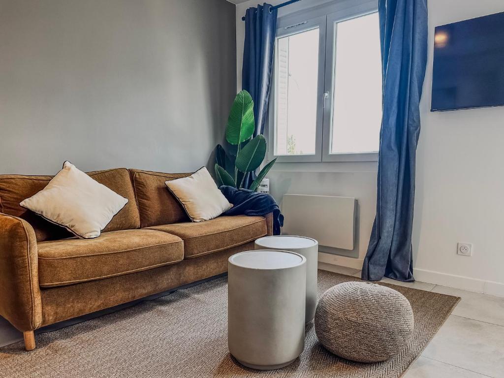 a living room with a brown couch and a window at Le Croizat - Neyrpic in Saint-Martin-dʼHères