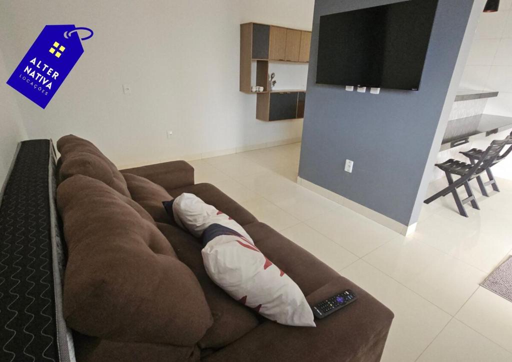 a brown couch with a pillow in a living room at Casa Coqueiro 02 in Primavera do Leste