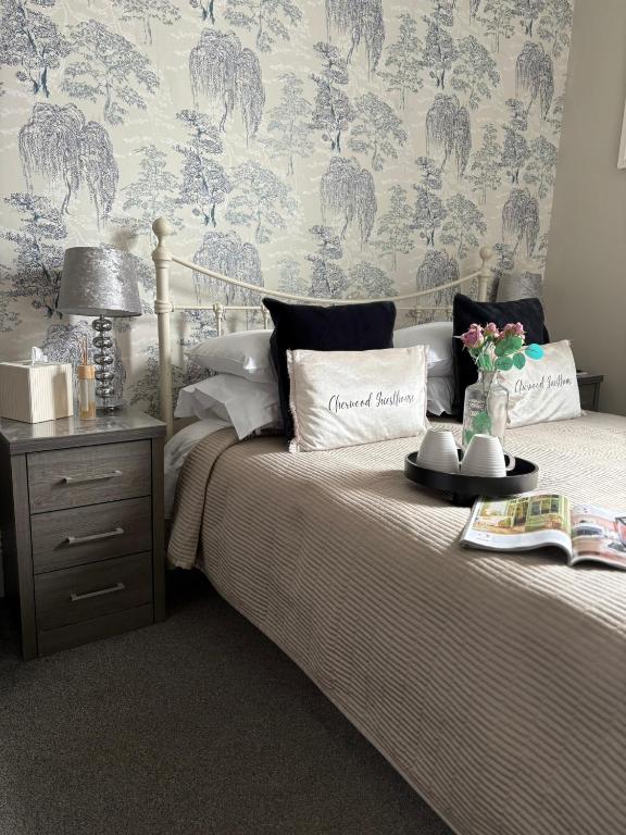 a bedroom with a bed with a blue and gray wallpaper at Cherwood Guest House in Paignton