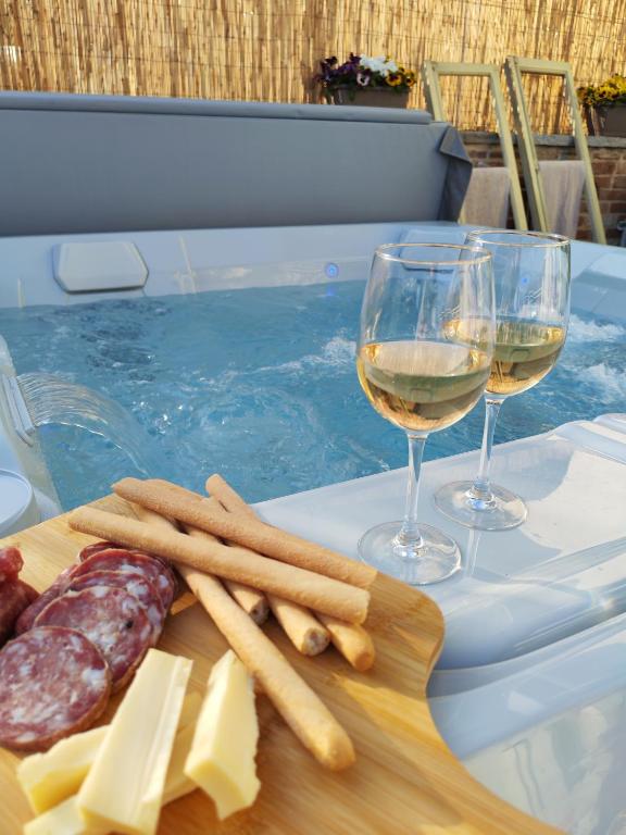 a tray of cheese and meat next to a glass of wine at B&B Barba Vigin in San Damiano dʼAsti