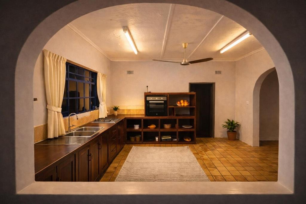 a large kitchen with a sink and a window at Spacious Victoria Falls Hideaway in Victoria Falls