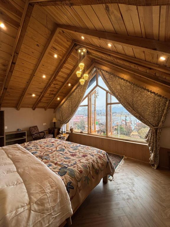 a bedroom with a bed in a room with a large window at Weather cottage in Srinagar