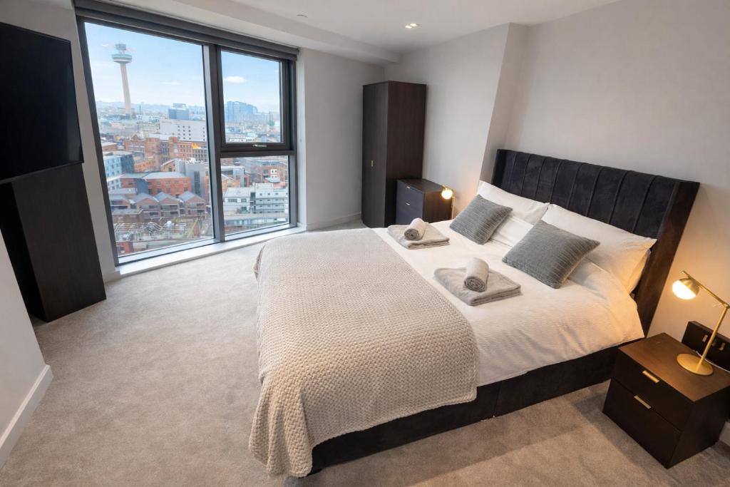 a bedroom with a large bed with a large window at Stunning Albert Dock Penthouse in Liverpool
