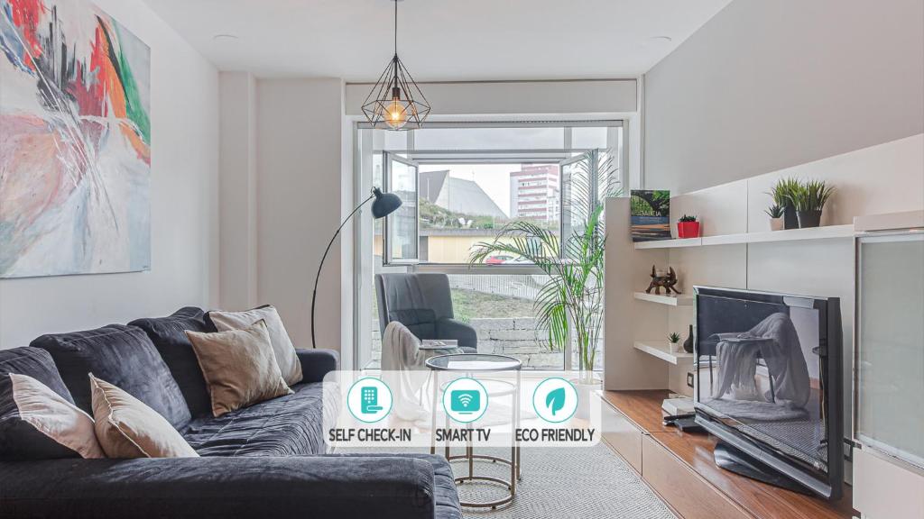 a living room with a couch and a tv at Blue Ocean Apartment in A Coruña