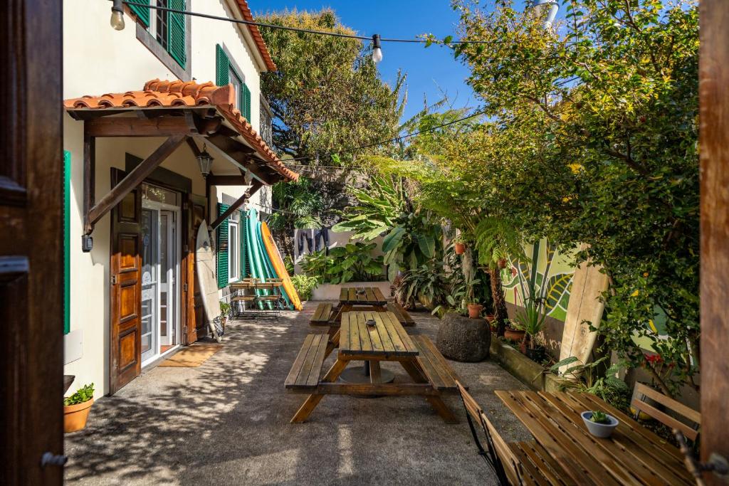 an alley with wooden picnic tables in a building at Jaca Hostel Porto da Cruz in Porto da Cruz
