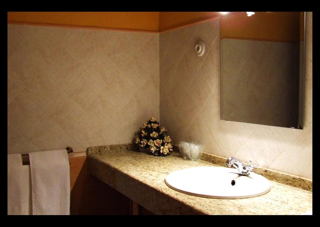 a bathroom with a sink and a mirror at Casa Rural La Chimenea in Navas del Madroño