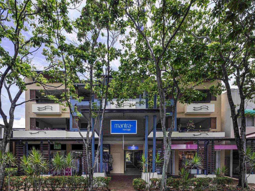 an apartment building with a metro sign in front of trees at Mantra Heritage in Port Douglas