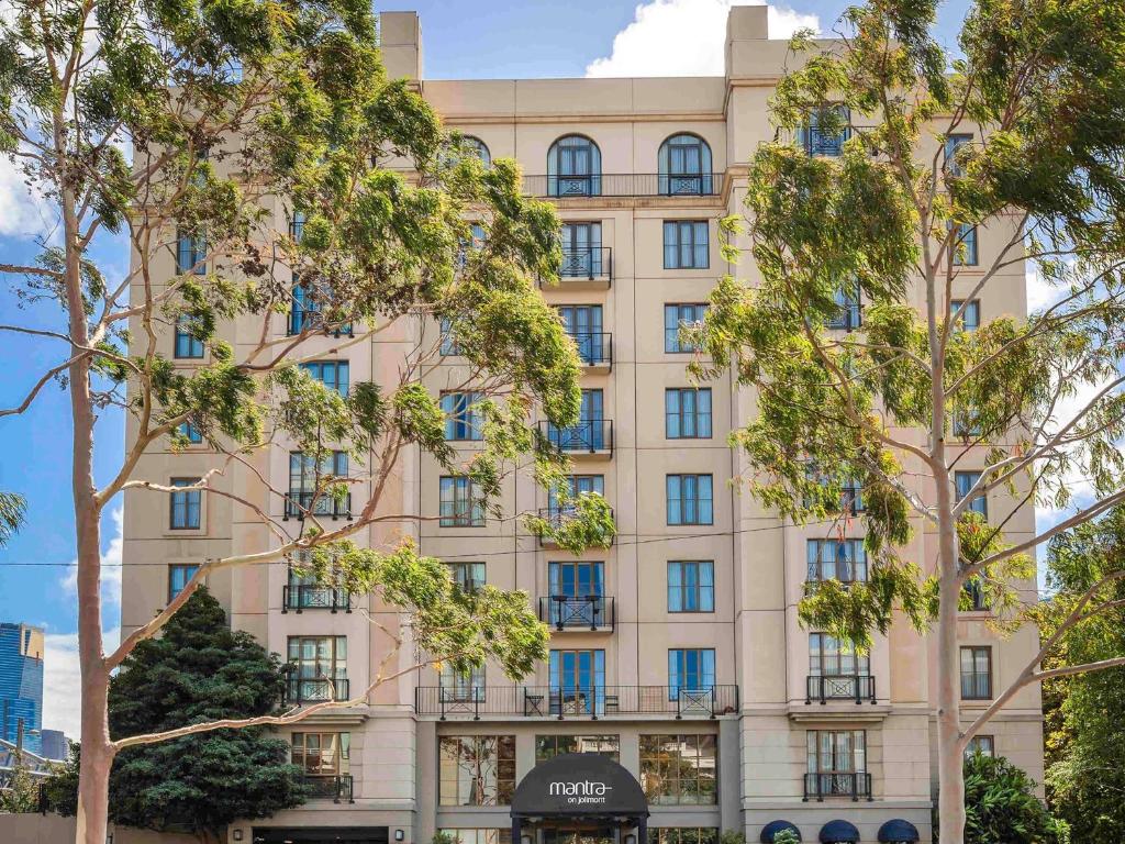 a building with trees in front of it at Mantra on Jolimont Melbourne in Melbourne