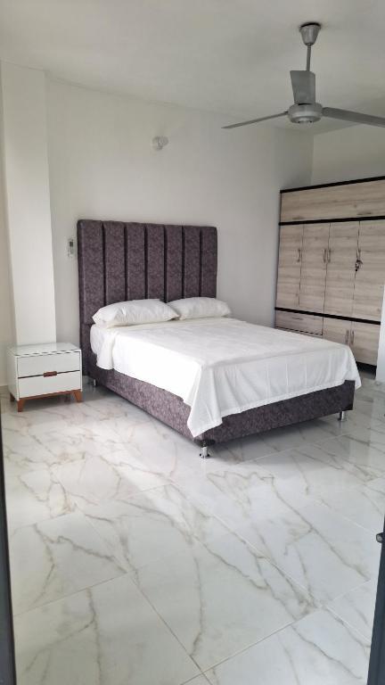 a bedroom with a large bed and a marble floor at Edificio Torre in Barrancabermeja