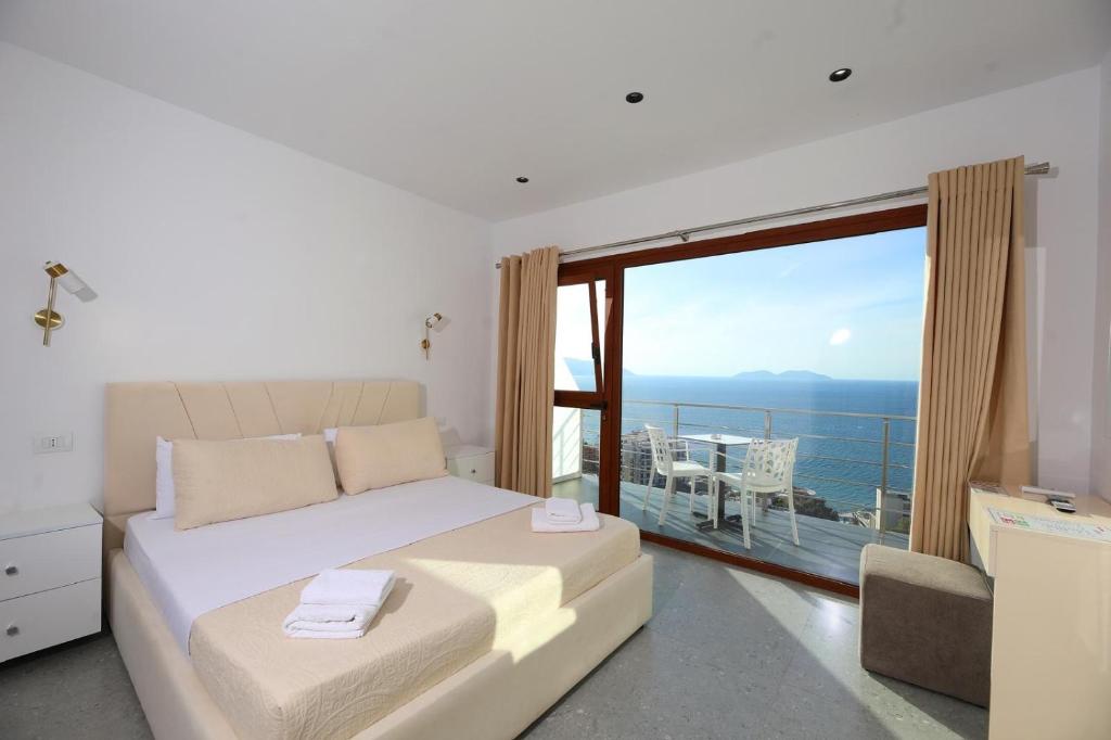 a bedroom with a bed and a large window at Hill Suites in Vlorë