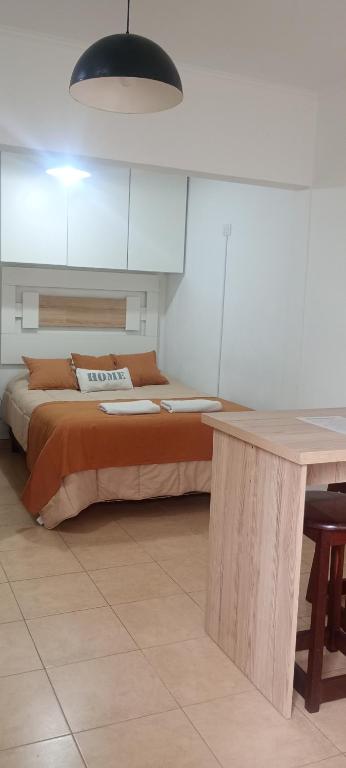 a bedroom with a bed and a table with a desk at Atenea B in Chivilcoy