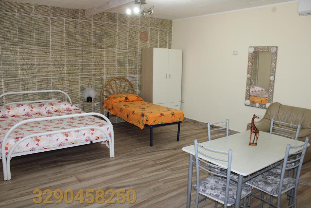 a bedroom with two beds and a table and a table and chairs at Casa vacanze da Cosimo BEIGE in Porto Cesareo