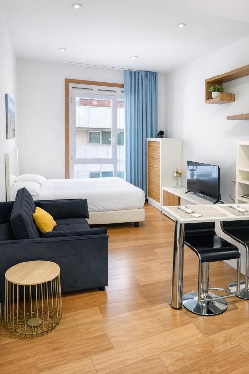 a bedroom with a bed and a couch and a desk at Apartamento Cúrcuma - Vigo Centro in Vigo