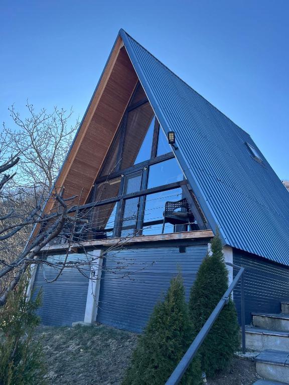 a house with a pitched roof with a window at La TRIUNGHIURI in Târgu Ocna