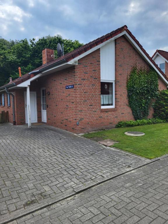 a brick house with a driveway in front of it at Haus Teelke in Papenburg