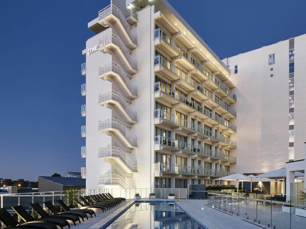 a hotel with a swimming pool in front of a building at Art Series - The Watson in Adelaide