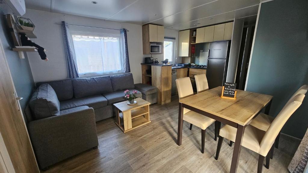 a small living room with a table and a kitchen at Eden 1708 in Canet-en-Roussillon