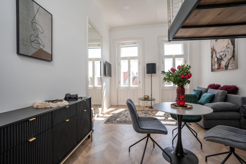 a living room with a couch and a table at V62 studio apartments- Downtown Sopron in Sopron