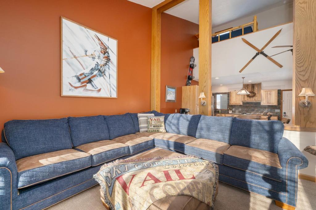 a living room with a blue couch and orange walls at Mountainside Unit B-20 in Granby