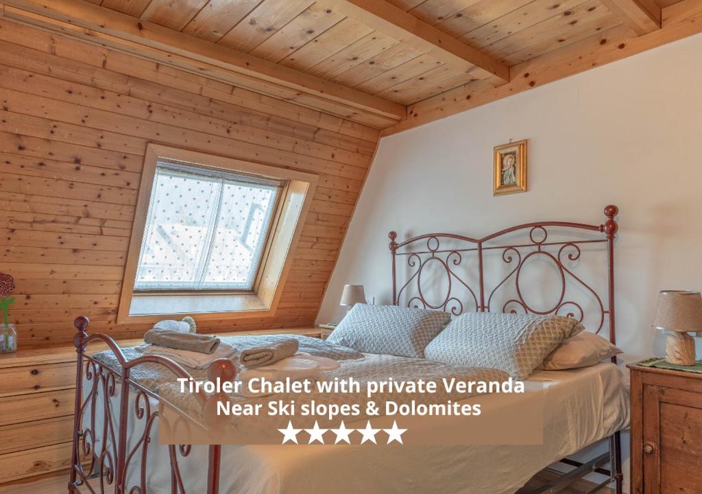 a bedroom with a bed in a room with wooden walls at Private Veranda - Tiroler Chalet - Near Ski Slopes & Dolomites in Carano