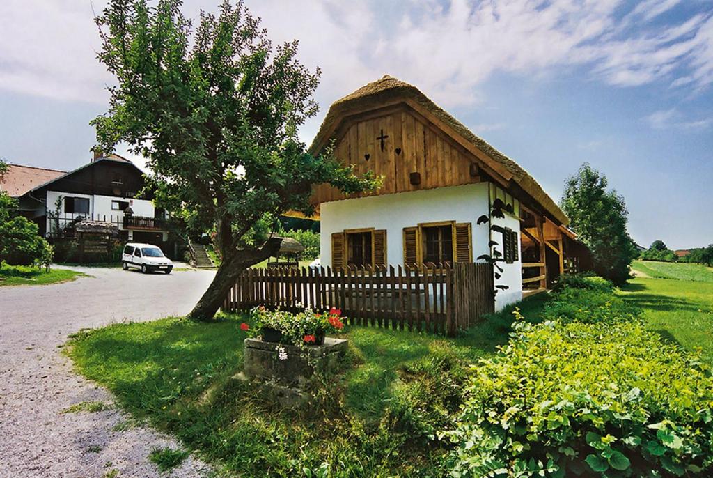 ein kleines Holzhaus mit einem Zaun davor in der Unterkunft Tourist Farm Ferencovi in Cankova