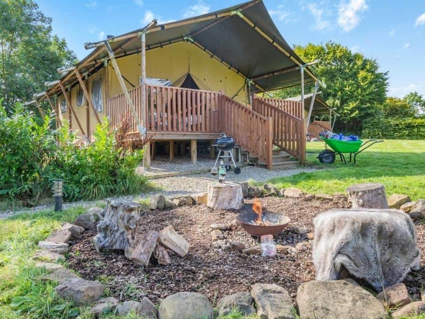 a backyard with a fire pit and a house at Little North Field Family Safari Tent Glamping near Harrogate in Harrogate