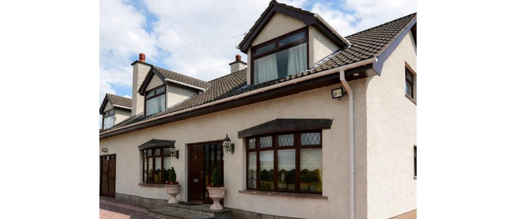 a white house with windows and a roof at Sleepy Hollow Apartment in Cushendun