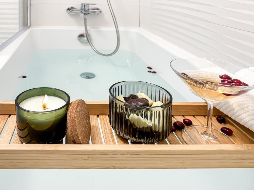 a tray with a bath tub with a candle and a wine glass at Cloud 9 Bucharest Residence in Bucharest