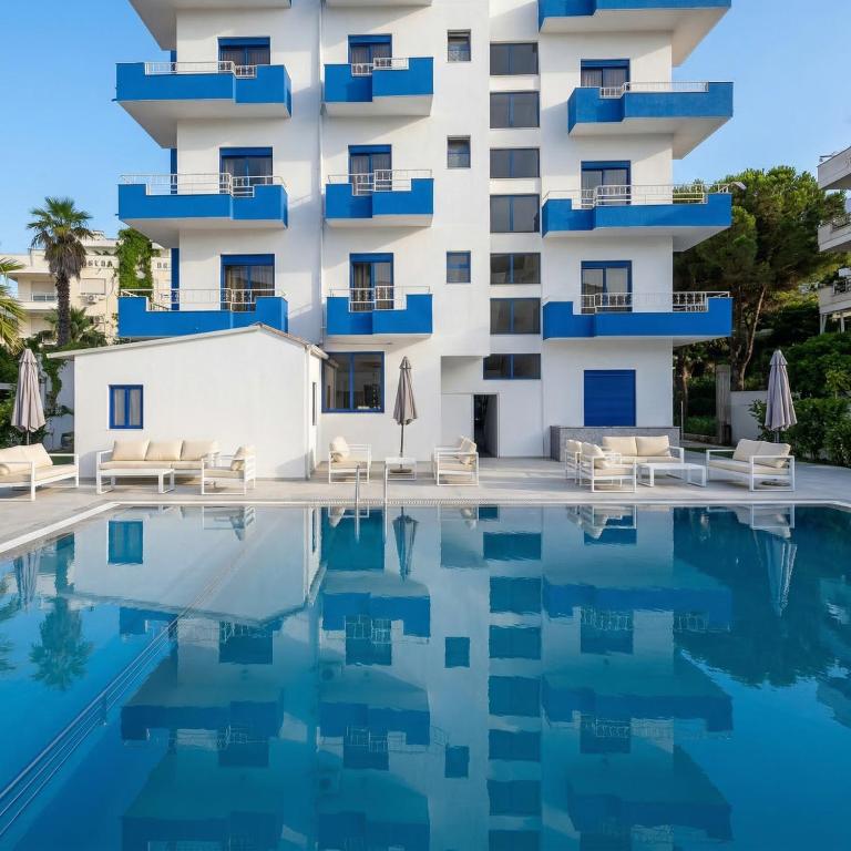 a hotel with a swimming pool in front of a building at Hotel BlueBalcony in Golem