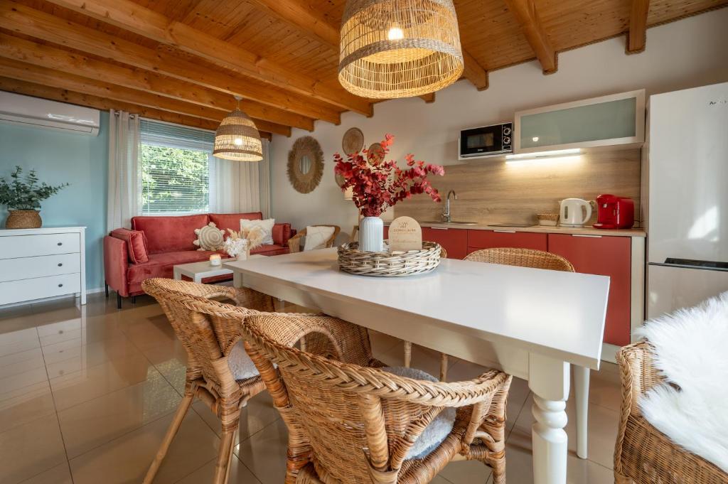 a kitchen and living room with a white table and chairs at DOMKI LAURA sauna & gorąca balia in Jastrzębia Góra