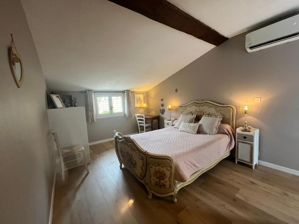 a bedroom with a large bed with white sheets and pillows at Chambres et Gîte PEYROUTAS " CAMILLE" Vignonet St Emilion in Vignonet