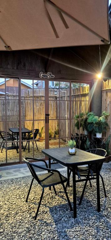 a patio with a table and chairs and an umbrella at Casa Elia San Juan La Union Beach Cabin in San Juan