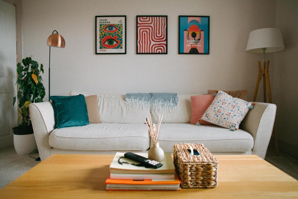 a living room with a couch and a table with books at Central Dundee, 1 Bed, Parking, 3 Nights in Dundee