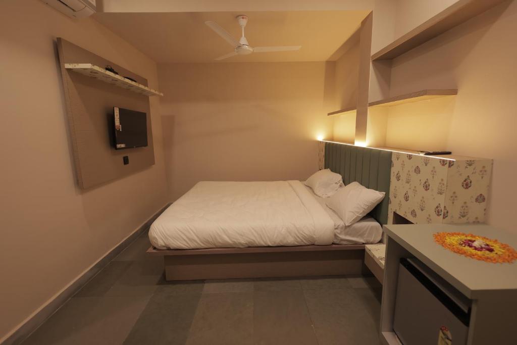 a small bedroom with a bed and a tv at Hotel Best Inn in Valsād